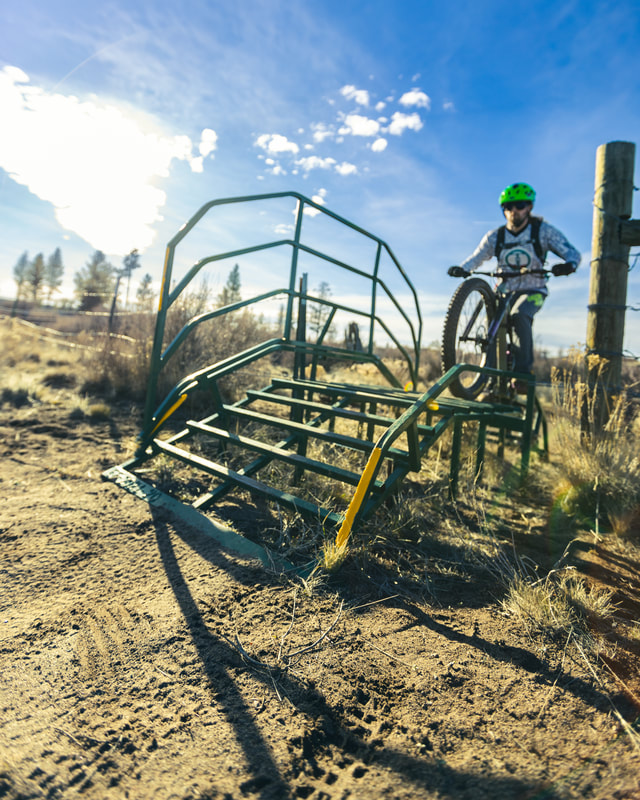 Biker riding up and over a metal cattle grate 